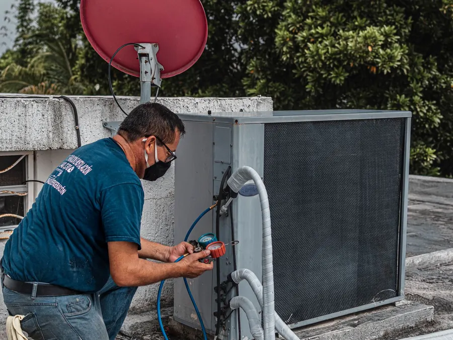 Técnico realizando manutenção em condensadora